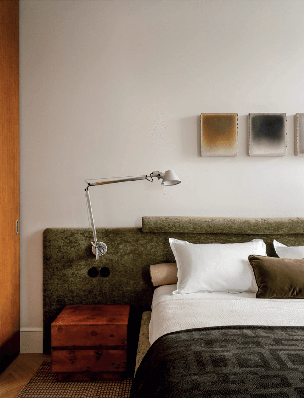 Bedroom with a wooden nightstand, desk lamp and green headboard